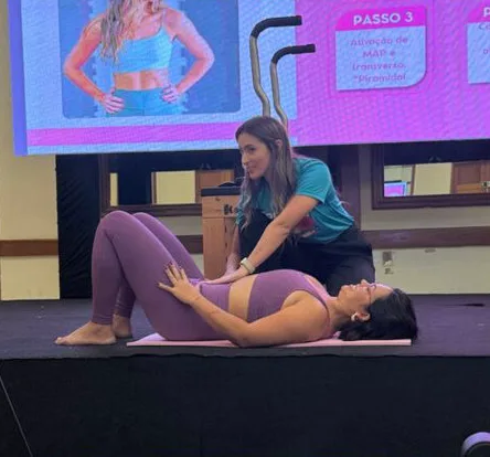 Carol conduzindo prática no palco